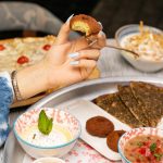 woman hand holding food over plate