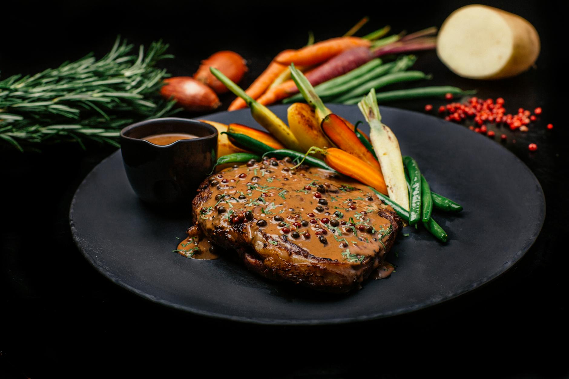 juicy ribeye steak with peppercorn sauce and vegetables