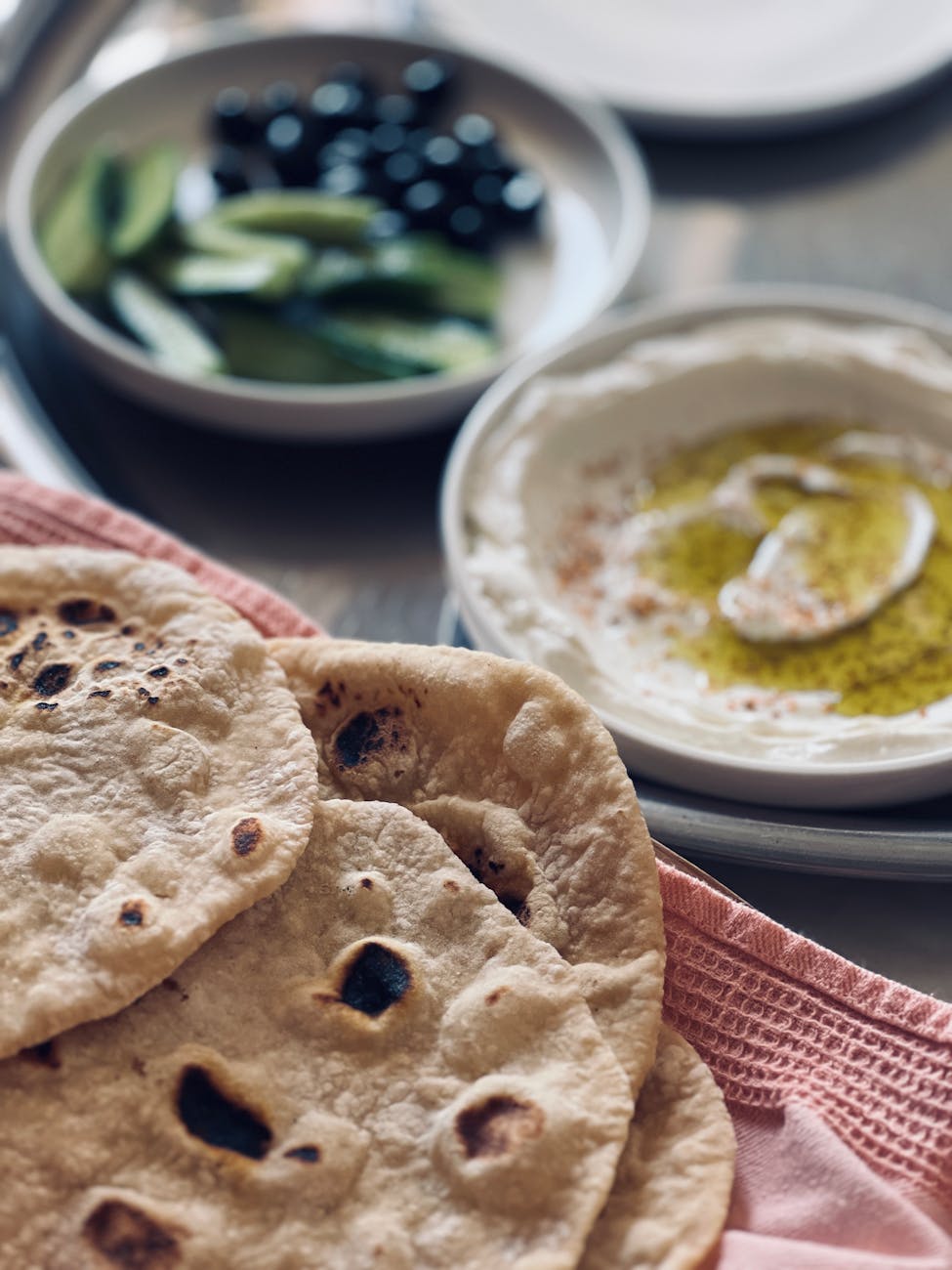 close up of fresh flatbreads with dips and olives